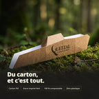 Boîte en carton recyclable Mon Quetzal - Compact (plié) posée dans une forêt, avec texte “Du carton, et c'est tout.” et icônes indiquant FSC, encre verte, 100% compostable, zéro plastique.